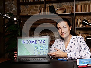 INCOME TAX text in search bar. Manager looking for something at cellphone. INCOME TAX concept. Aa type ofÃÂ taxÃÂ that governments photo